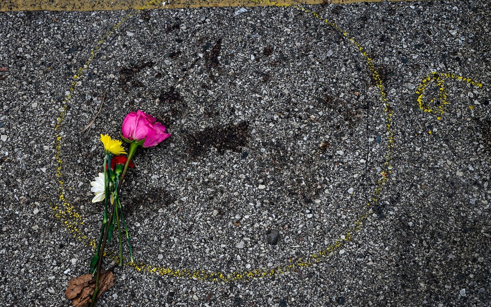 Flor é vista ao lado de pintura feita pela polícia para marcar local onde manifestante foi baleado em Kenosha, Wisconsin, na quarta-feira (26 — Foto: AP Photo/Morry Gash