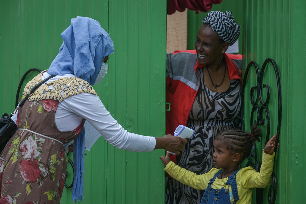 20 de abril: agente do Ministério da Saúde da Etiópia mede a temperatura de uma menina em Addis Abeba para tentar conter a disseminação do novo coronavírus. — Foto: Michael Tewelde / AFP