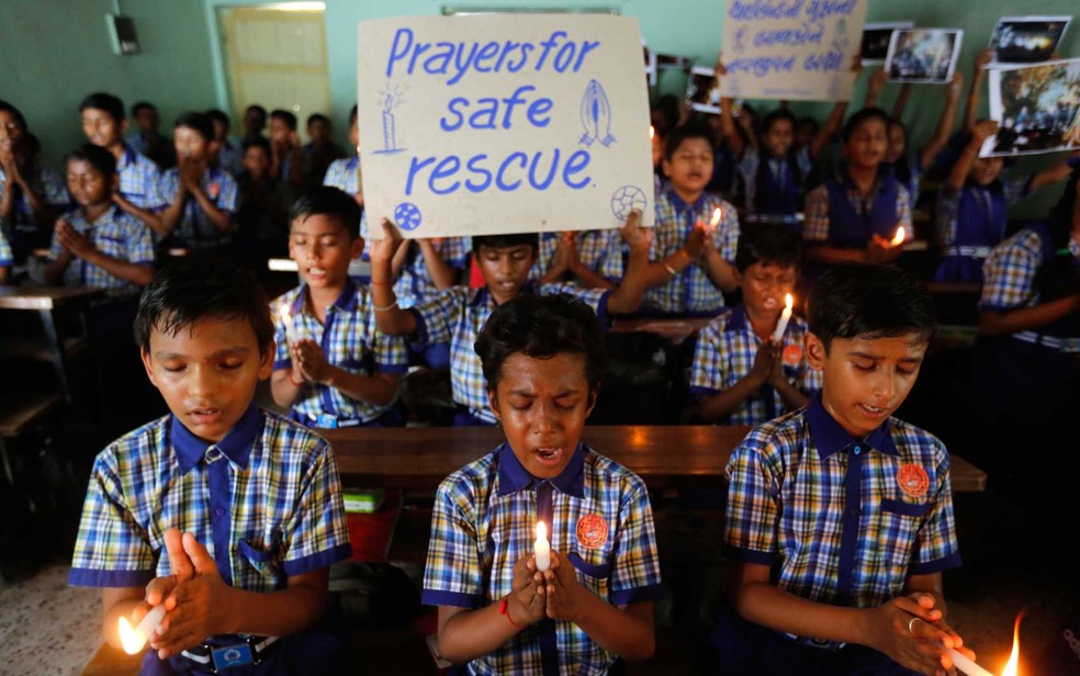 Estudantes indianos de escola em Ahmadabad rezam por garotos que ainda estão presos na caverna na Tailândia (Foto: Ajit Solanki / AP Photo)