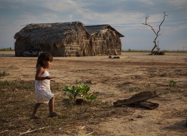 A pequena Meime, 2 anos, brinca com um pedaço de galho. Brinquedo é artigo raro em sua aldeia.  (Foto: Lalo de Almeida)