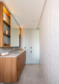 Neste apartamento projetado pela Voilà Studio, o revestimento do banheiro da suíte é da Eliane. Branco e madeira se encontram novamente, dando unidade ao projeto