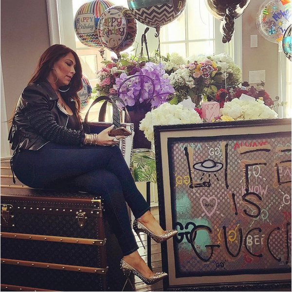 A empresária de Mariah Carey, Stella Bulochnikov, sentada em cima da mala dada pela cantora (Foto: Instagram)