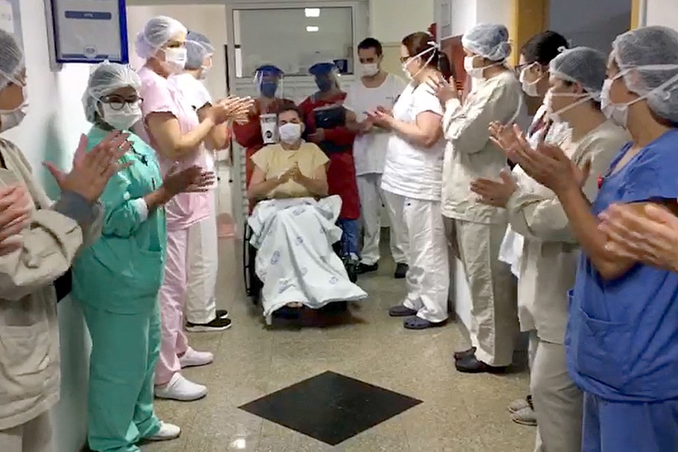 Profissionais aplaudem paciente da Covid-19 que recebeu alta após dias na UTI — Foto: Detran/AEN