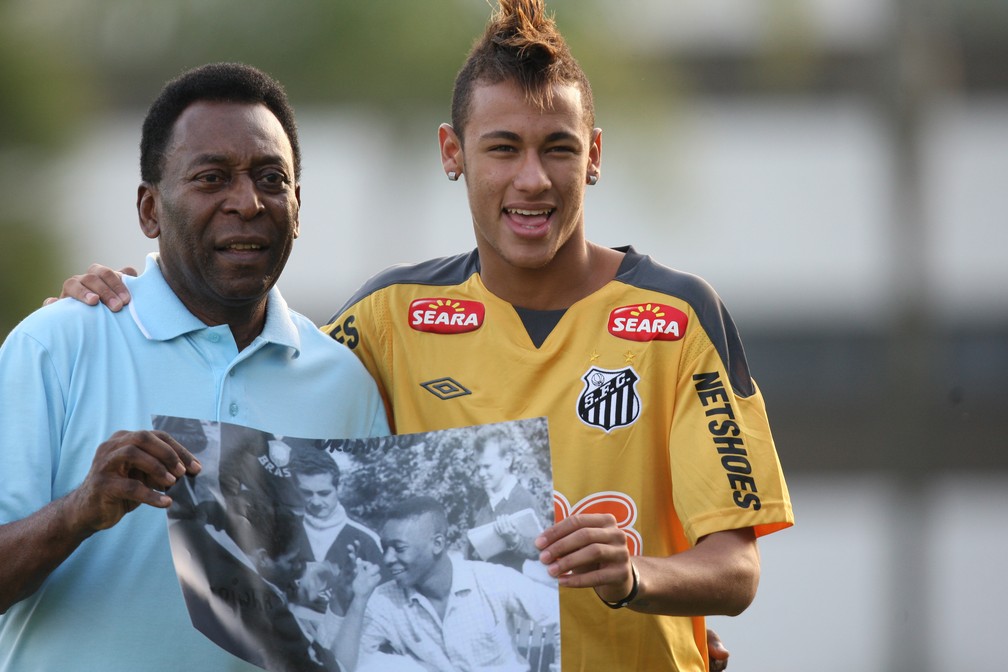 Pelé exibe foto de quando tinha cabelo igual ao do atacante Neymar, no CT Rei Pelé, na Baixada Santista (SP), em junho de 2011 — Foto: Ernesto Rodrigues/Estadão Conteúdo/Arquivo