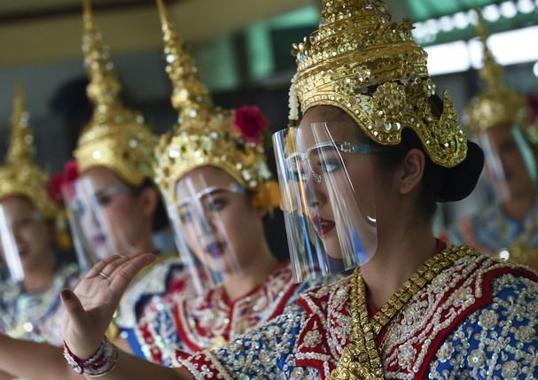 Traditional Thai dancers use face shields while performing for worshippers, after the government eased some coronavirus restrictions, at Erawan shrine, in Bangkok, Thailand, 04 May 2020. (Photo by Anusak Laowilas/NurPhoto via Getty Images) (Foto: NurPhoto via Getty Images)