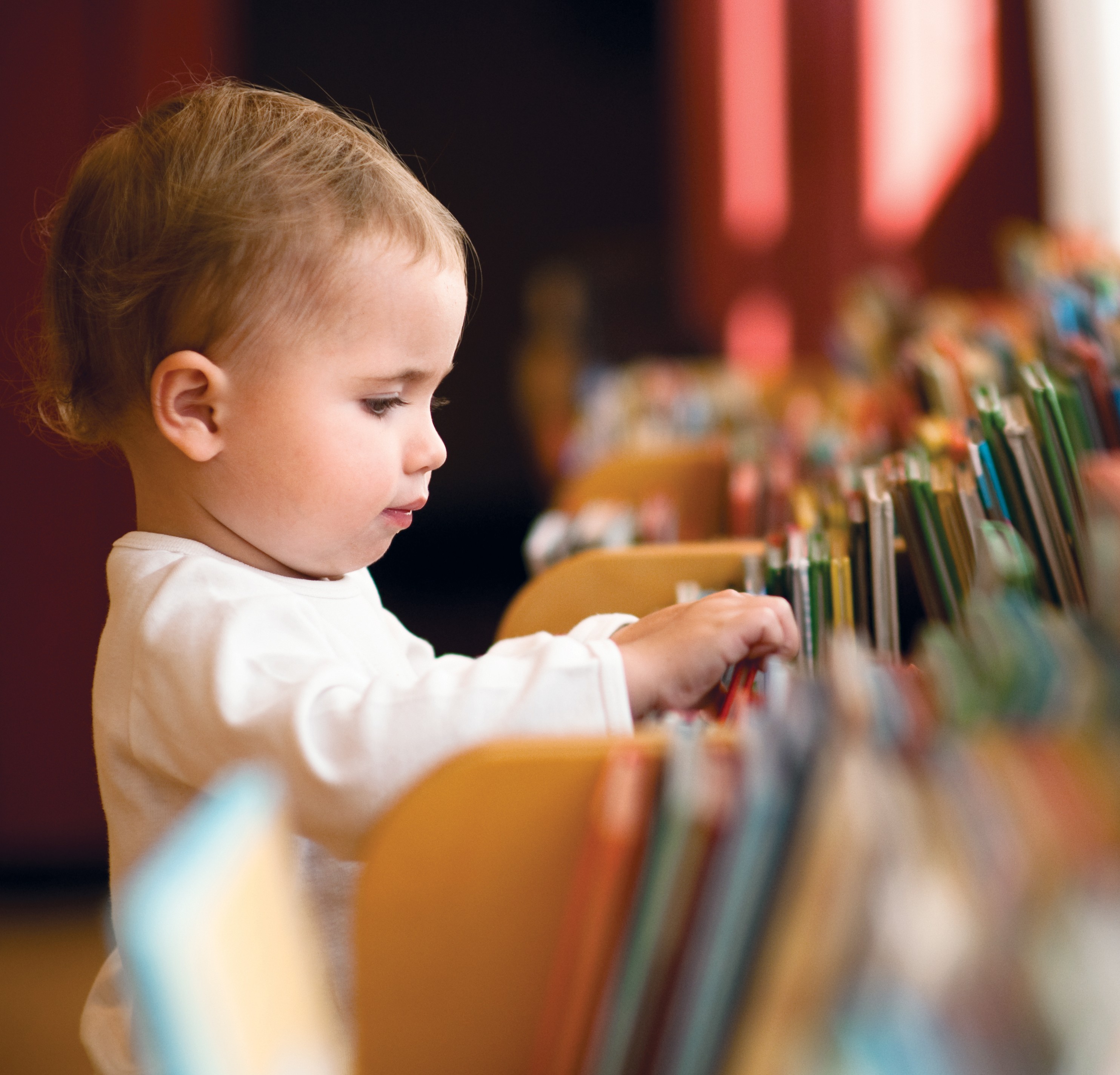 Little girl flicking trough books in a library. Natural light. (Foto: Getty Images)