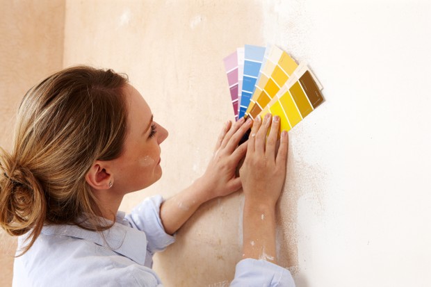 Young woman choosing colour scheme in new home (Foto: Getty Images)
