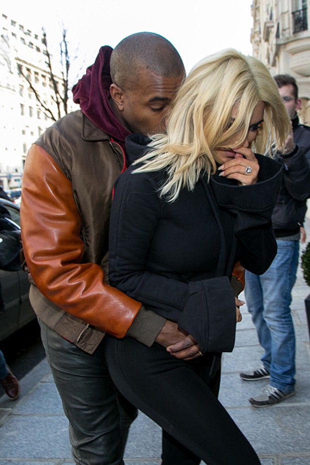 Kanye West "protege" derrière de Kim Kardashian dos flashes na PFW