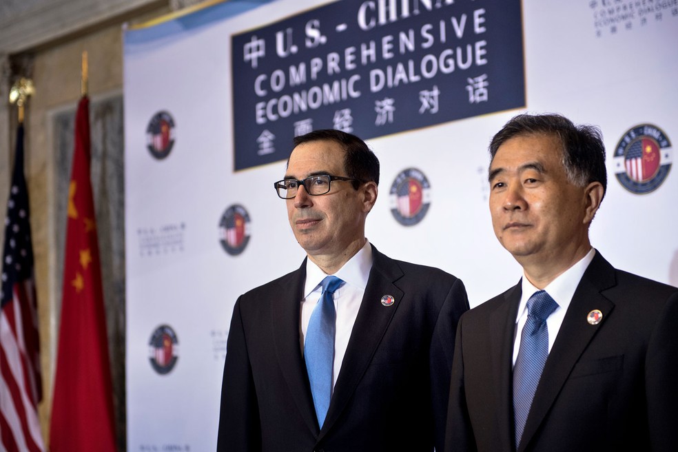 O secretário do Tesouro dos EUA, Steven Mnuchin, e o vice-premiê chinês Wang Yang em encontro neste sábado (19) em Washington (Foto: Brendan Smialowski/AFP)