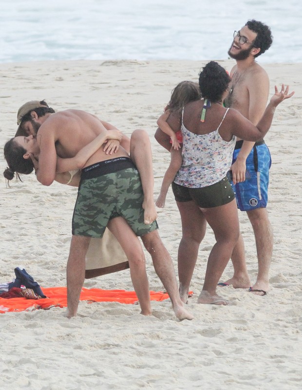 Laura Neiva e Chay Suede trocam beijos em dia de praia com filhos e amigos (Foto: Fabricio Pioyani/AgNews)