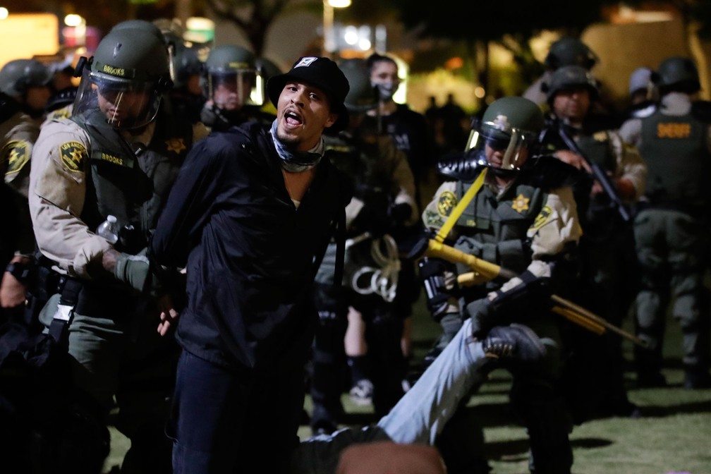 Manifestante é preso por violar o toque de recolher na quarta-feira (3) no centro de Los Angeles  — Foto: Marcio Jose Sanchez/AP 