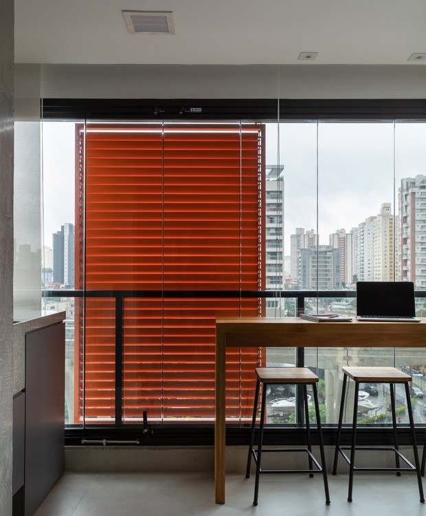 A varanda também funciona como home office ou bancada de refeições com vista da Av. Roberto Marinho à noite (Foto: Lufe Gomes/Divulgação)