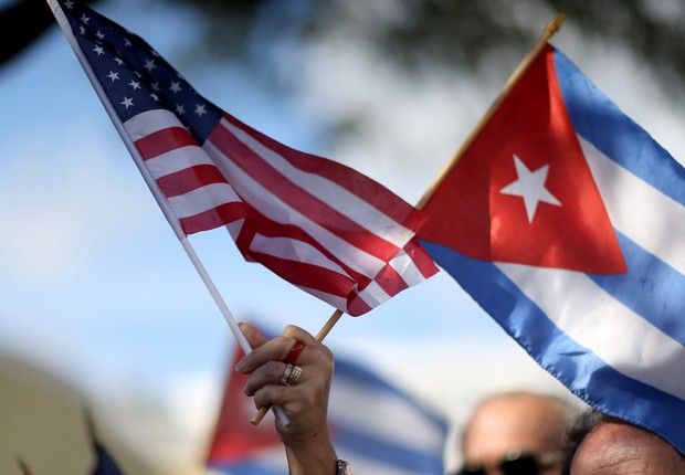 Manifestante segura bandeiras de Cuba e dos Estados Unidos (Foto: Joe Raedle/Getty Images)
