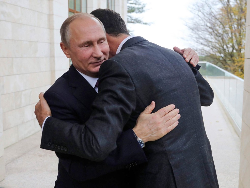 Os presidentes da Rússia e da Síria, Vladimir Putin (esq.) e Bashar al.Assad, se abraçam em encontro na residência presidencial russa Bocharov Ruchei no Mar Negro — Foto: Mikhail Klimentyev/Kremlin pool via AP