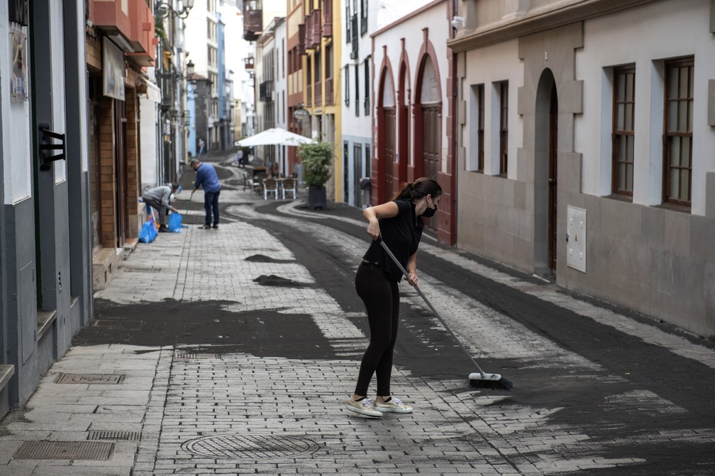 Moradores limpam as cinzas em rua em Santa Cruz de la Palma, na ilha de La Palma, em 27 de setembro de 2021 no arquipélago espanhol das Canárias — Foto: Saul Santos/AP