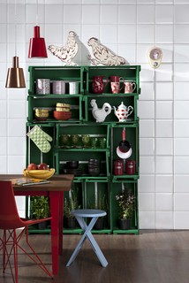 Equilibrados, os caixotes formam uma estante na cozinha, com panelas, peças de louça e vasos com ervas. Para garantir a estabilidade, eles devem ser parafusados uns nos outros e, depois, chumbados na parede
