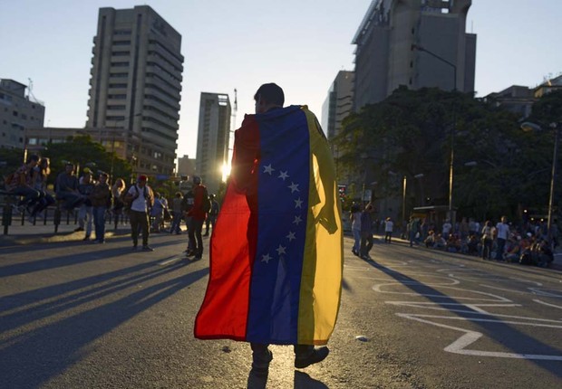 Manifestante carrega bandeira da Venezuela durante protesto contra o governo de Nicolás Maduro (Foto: Raul Arboleda)