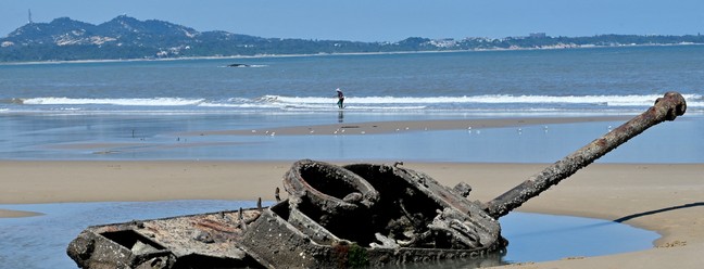 Destroços de um tanque antigo são vistos na praia Ou Cuo Sandy, nas ilhas Kinmen de Taiwan, a apenas 3,2 km da costa da China continental  — Foto: SAM YEH / AFP