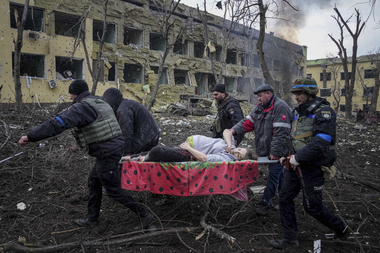 Funcionários e voluntários de emergência ucranianos carregam uma mulher grávida ferida da maternidade em Mariupol, na UcrâniaAgência O Globo