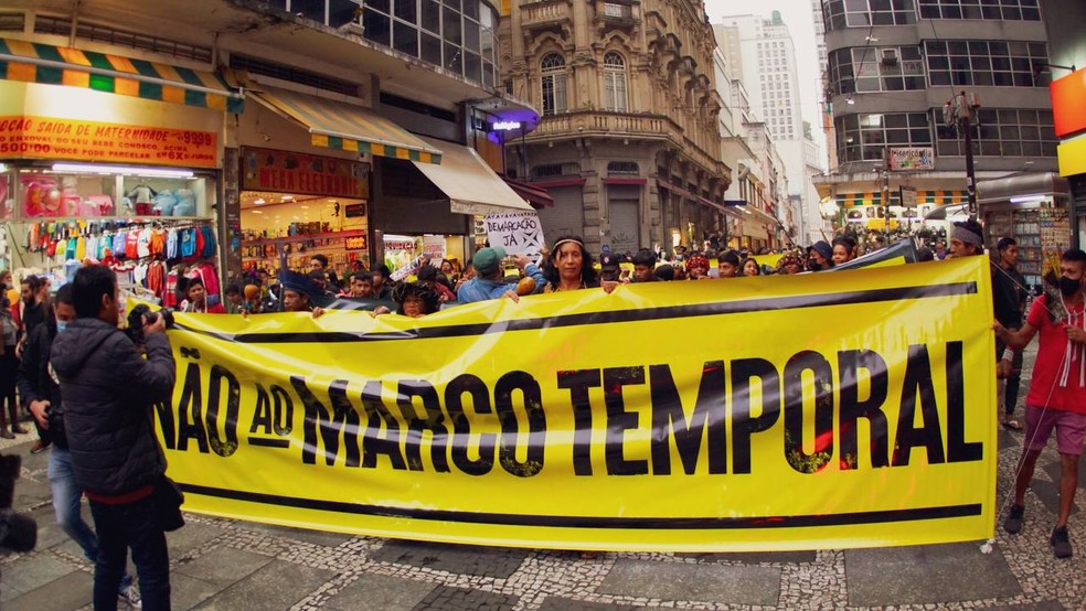 Manifestantes com cartaz contra o marco temporal na demarcação de terras indígenas. — Foto: Divulgação/ Isa Luchtenberg