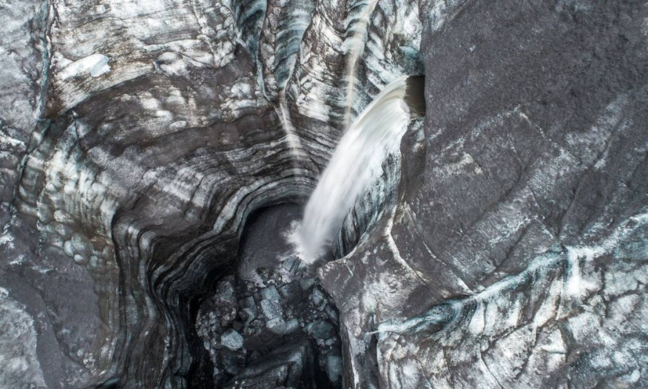 Rio sub-glacial vindo de dentro de uma geleira e caindo num grande buraco — Foto: Florian Ledoux