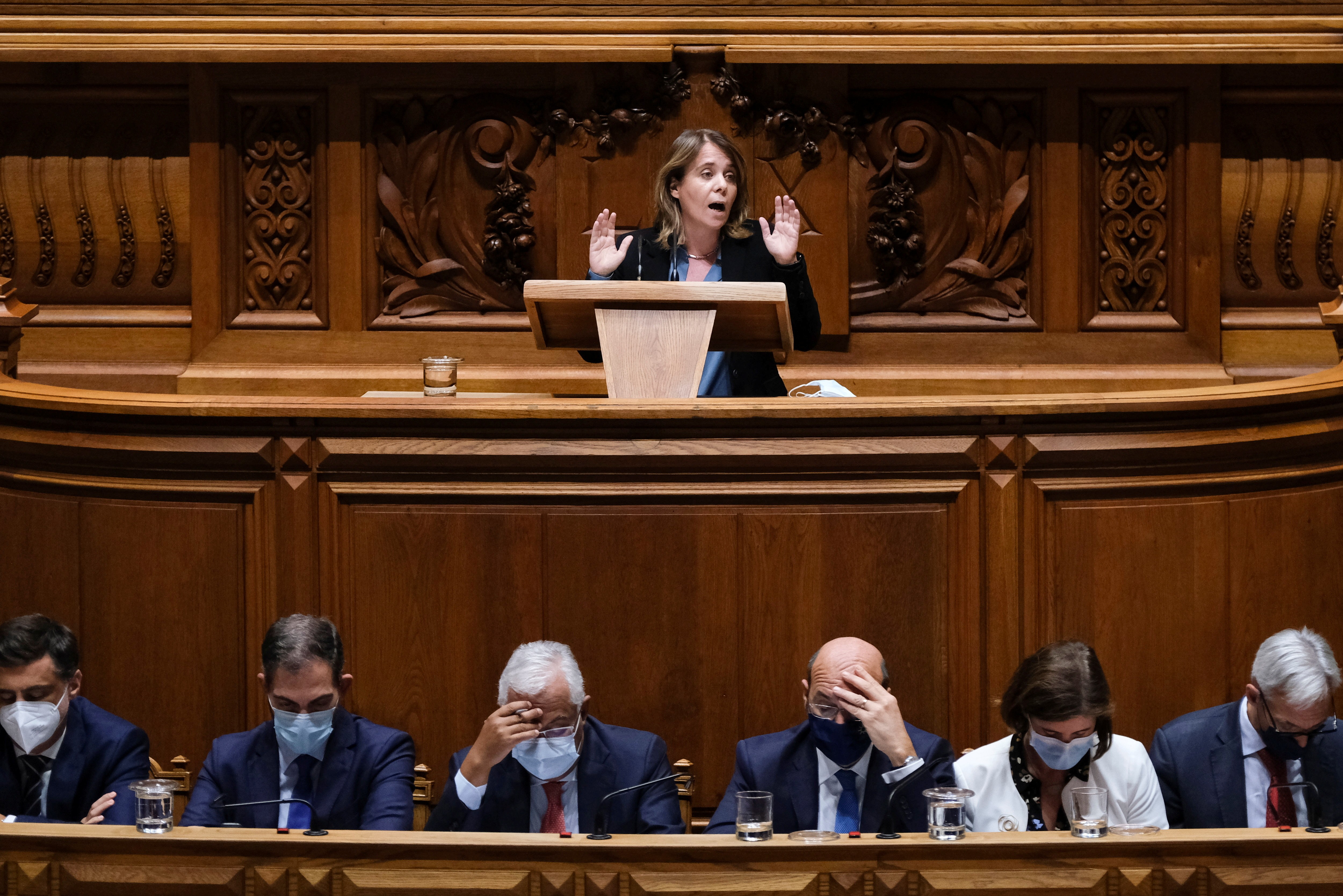 Catarina Martins, do Bloco de Esquerda, discursa no Parlamento em 2021. Abaixo, Costa e ministros