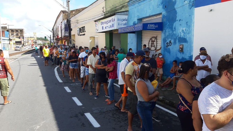 Longa fila se formou na porta da agência da Caixa ao lado da linha do trem em Rio Largo, Alagoas — Foto: CW Sonorização