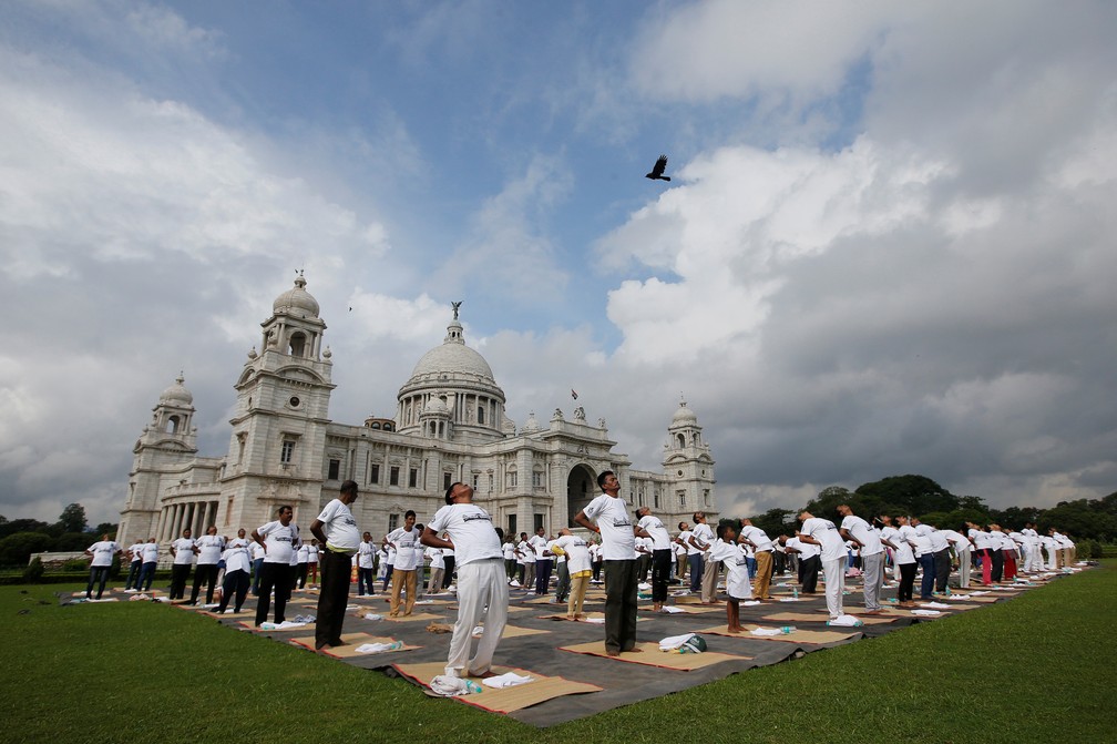 Membros da Força de Segurança Industrial Central (CISF) praticam yoga em frente ao monumento histórico Victoria Memorial, construído durante o domínio colonial britânico, no Dia Internacional do Yoga em Kolkata, na Índia — Foto: Rupak De Chowdhuri/Reuters