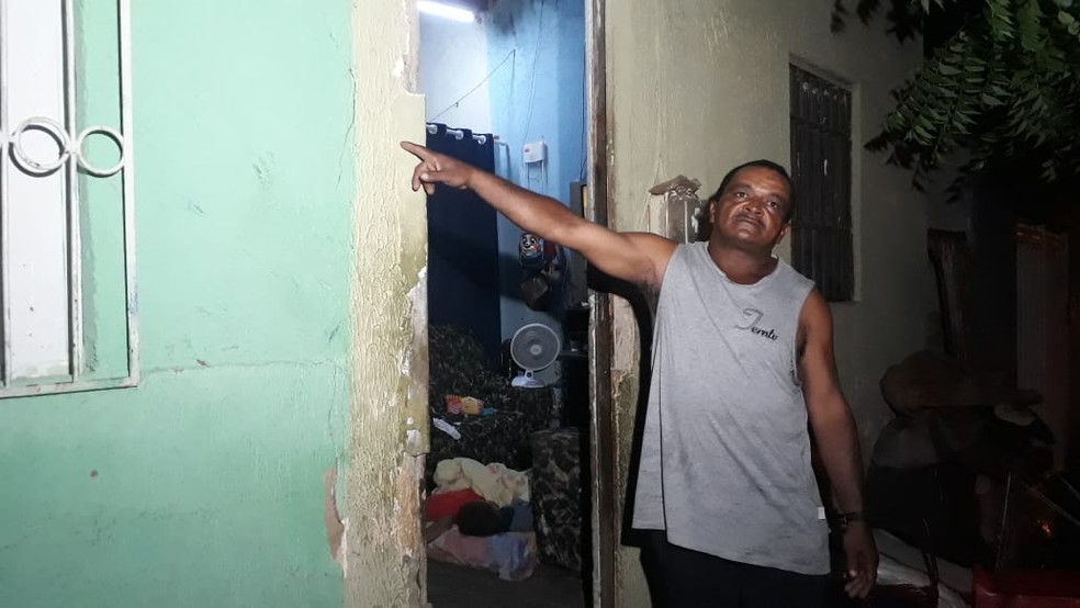 O reciclador Gilvan Pereira mostra rachaduras que surgiram na parede de casa após as explosões — Foto: Arnaldo Araújo