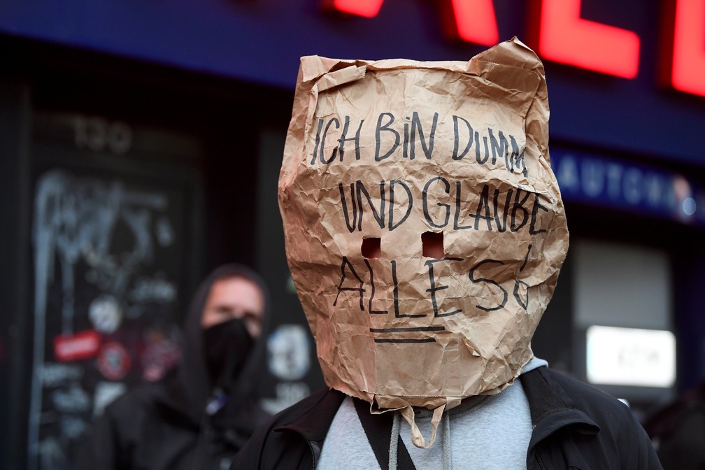 Manifestante usa saco de papel com a mensagem 'Sou burro e acredito em tudo!' durante protesto em Hamburgo, na Alemanha — Foto: Fabian Bimmer/Reuters