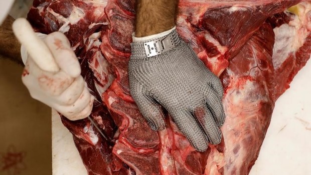 Funcionário corta pedaço de carne em um açougue em São Paulo (Foto: Paulo Whitaker/Reuters)
