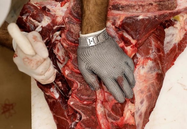 Funcionário corta pedaço de carne em um açougue em São Paulo (Foto: Paulo Whitaker/Reuters)