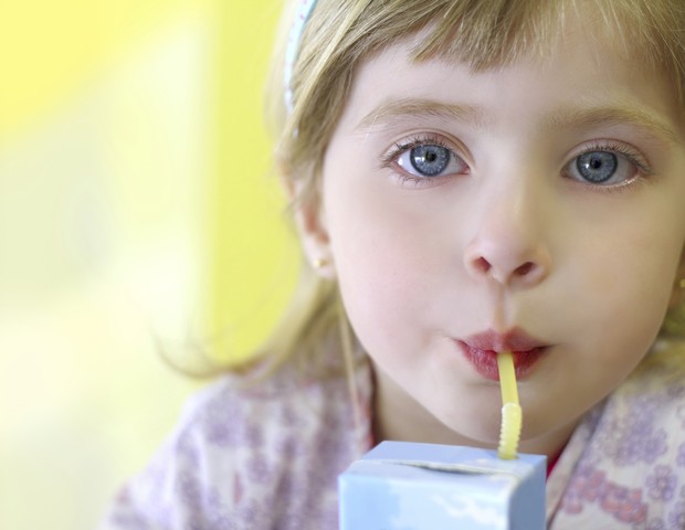 Menina bebendo suco de caixinha (Foto: Thinkstock)