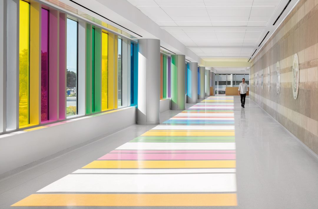 Corredor do hospital Omaha VA Care Center, nos Estados Unidos, reflete luzes coloridas por causa dos vidros com cores (Foto: AJ Brown Photography/ ©LEO A DALY)