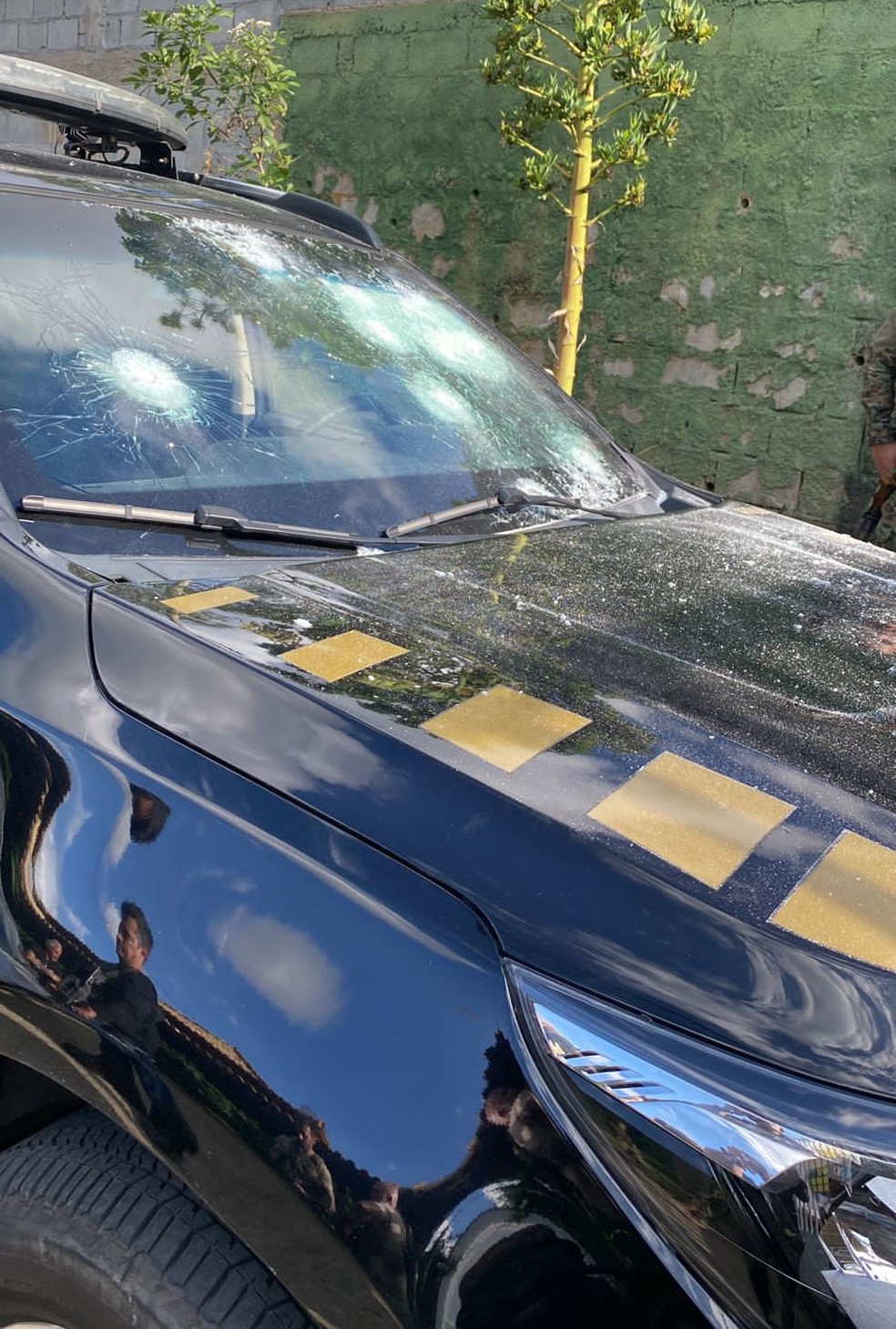 Vidro do carro da PF atingido por tiro  — Foto: Reprodução 