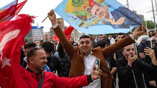 Apoiadores do presidente turco Recep Tayyip Erdogan comemoram perto da Mesquita Taksim, na Praça Taksim, em Istambul, no dia do segundo turno presidencial. — Foto: Yasin AKGUL / AFP