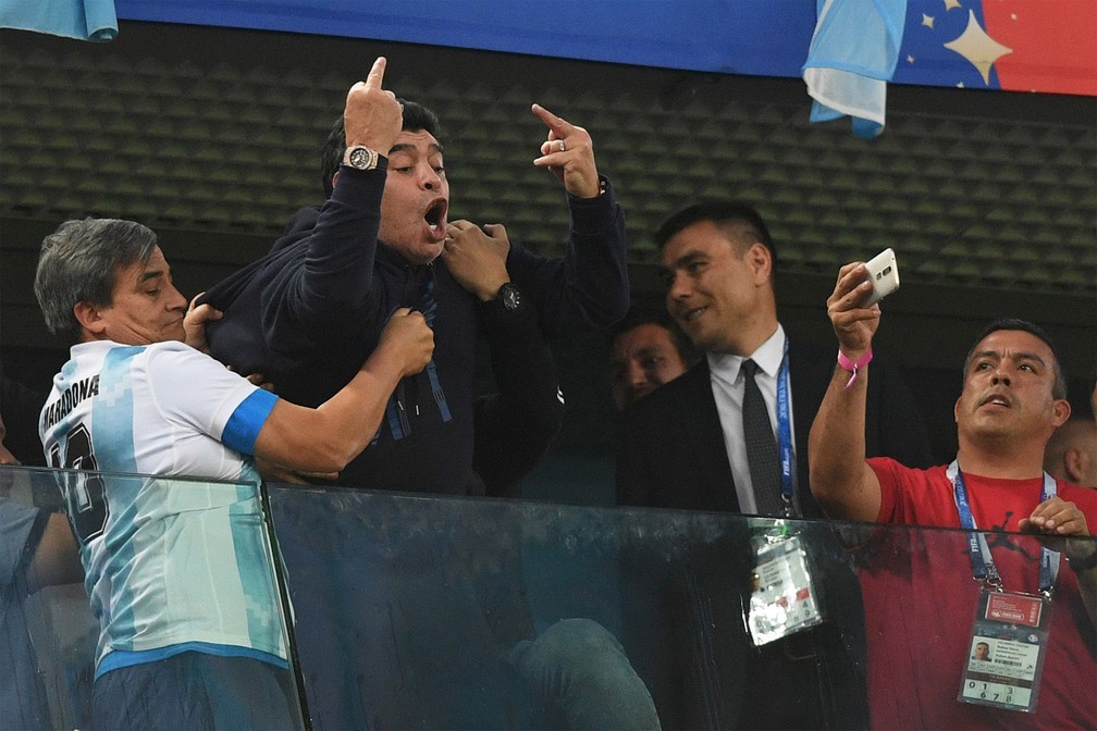 Diego Maradona mostra os dedos do meio para o campo após lance controverso do jogo entre Argentina e Nigéria na Copa do Mundo da Rússia, em São Petersburgo, em junho de 2018 — Foto: Olga Maltseva/AFP