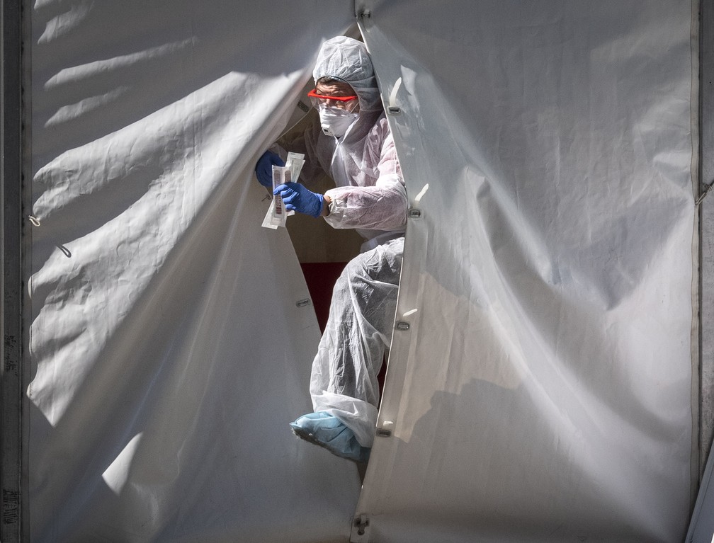 2 de maio: profissional de saúde sai de tenda de testagem para Covid-19 com amostras para análise em Moscou, na Rússia. — Foto: Yuri Kadobnov / AFP