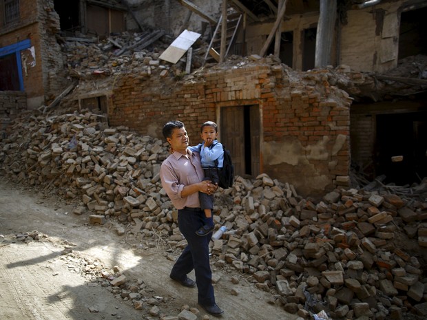Birendra Karmacharya carrega seu filho de 4 anos rumo ao primeiro dia de aulas após o terremoto que destruiu o Nepal (Foto: Reuters/Navesh Chitrakar)