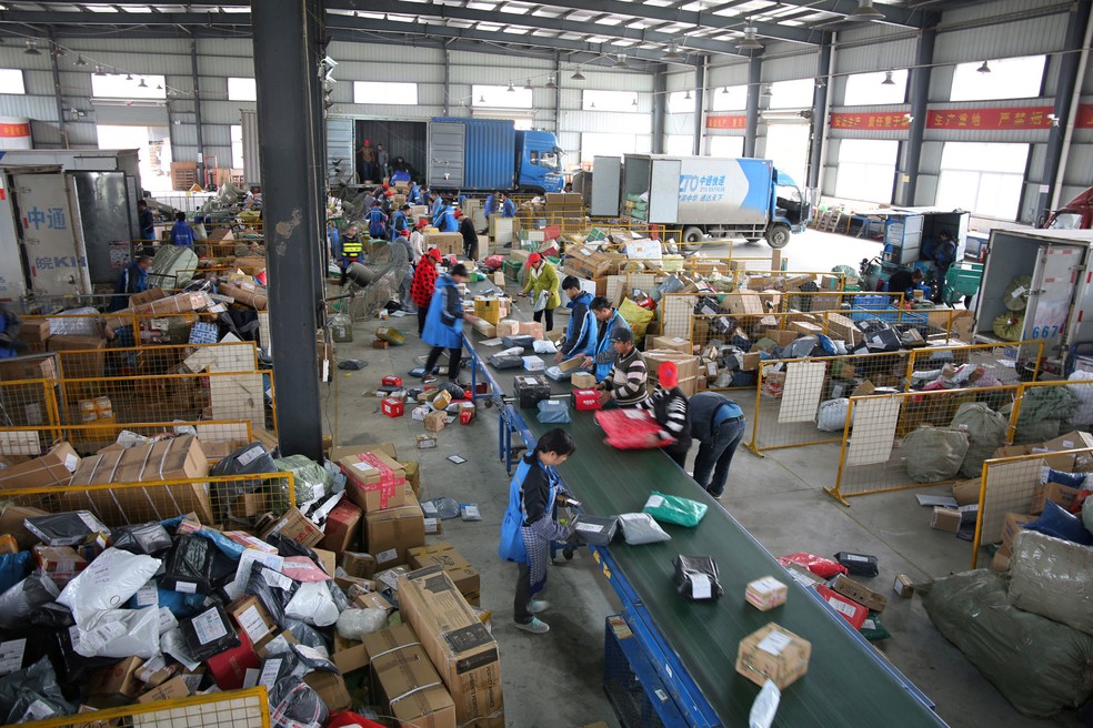  Funcionários de um centro de logística em Fuyang, província de Anhui, na China, parceiro do Alibaba, separam produtos comprados durante o Dia dos Solteiros, festival de compras do gigante do e-commerce chinês, no sábado (11) (Foto: Stringer/Reuters)