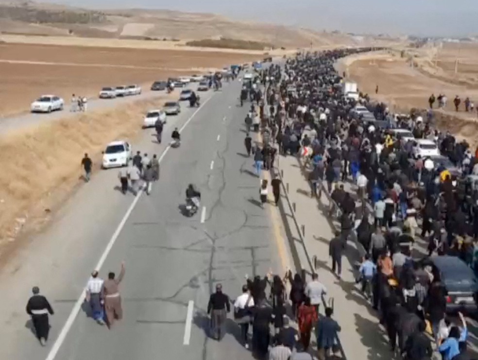 Multidão marcha pela estrada que leva ao Cemitério de Aychi, onde Mahsa Amini está enterrada, perto de Saqez, no Irã, nesta captura de tela tirada de um vídeo de mídia social divulgado em 26 de outubro de 2022 — Foto: Reprodução via Reuters