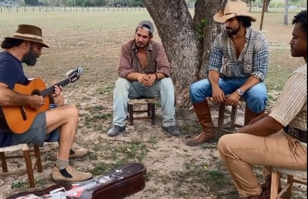 Almir Sater toca e canta para Renato Góes. Thomaz Cividanes e Fabio Neppo em Corumbá (MS) nos bastidores de 'Pantanal' (Foto: Reprodução/Facebook)