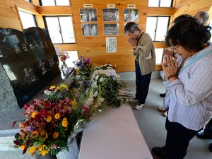 Turistas em memorial às vítimas do tsunami (Foto: Toru Yamanak/AFP)