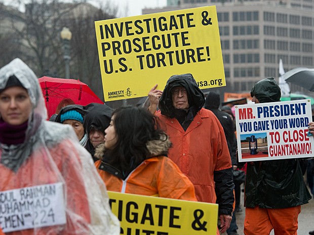 'Investiguem e processem a tortura dos EUA', diz cartaz exibido no protesto (Foto: Nicholas Kamm/AFP)