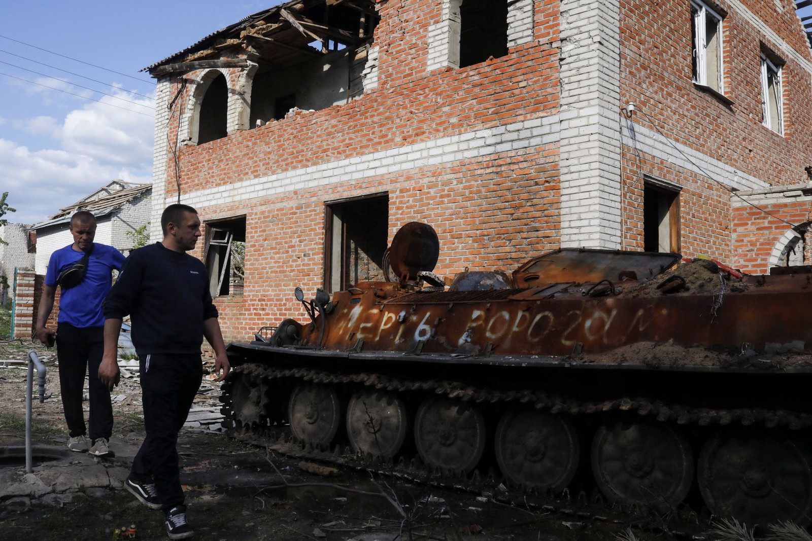Vladimir visita sua casa danificada, onde um veículo de combate russo destruído está estacionado na Malásia Rohan, uma vila retomada pelas forças ucranianas na região de Kharkiv — Foto: Ricardo Moraes/REUTERS
