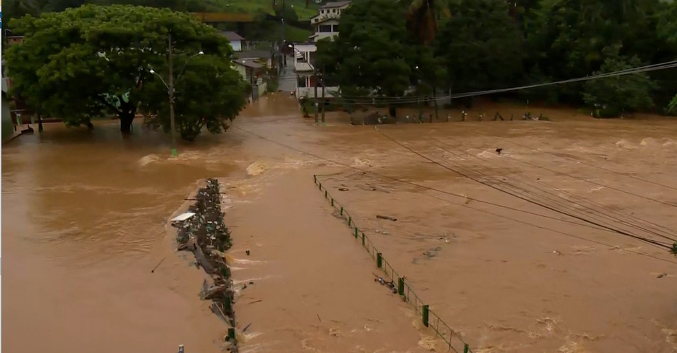 Rio em Fundão transbord, encobre ponte a e alaga trechos da cidade — Foto: Reprodução/TV Gazeta