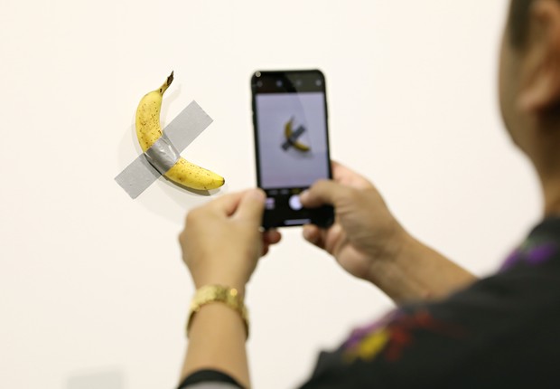 Homem fotografa Comedian, a banana de US$ 120 mil (Foto: Cindy Ord/Getty Images)
