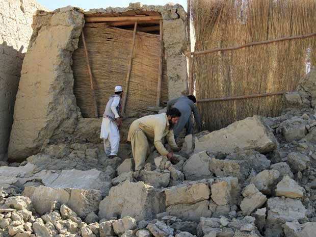 Homens afegãos trabalham em uma casa no distrito de Behsud, província de Nangarhar, no Afeganistão (Foto: Parwiz / Reuters)