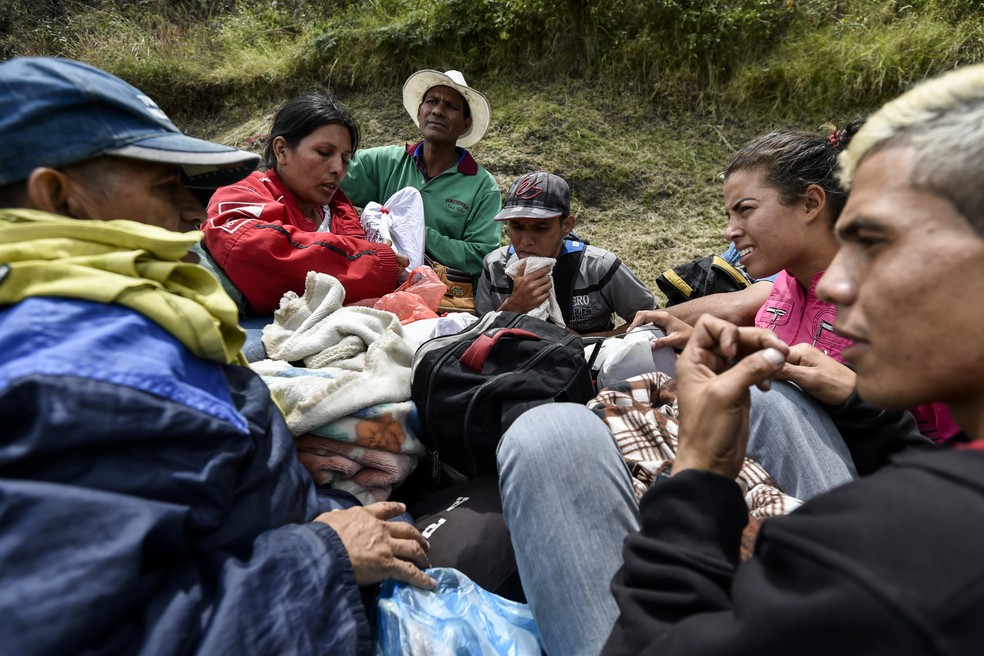 Imigrantes venezuelanos viajam em caçamba de caminhonete pela estrada Panamericana, na Colômbia (Foto: Luis Robayo/ AFP)