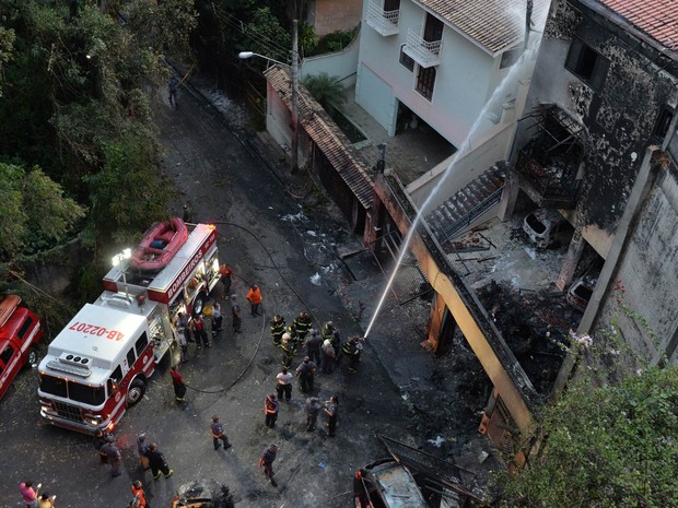 Bombeiros trabalham na área onde um avião monomotor caiu em uma casa no bairro da Casa Verde, em São Paulo, após decolagem do Campo de Marte (Foto: Nelson Almeida/AFP)